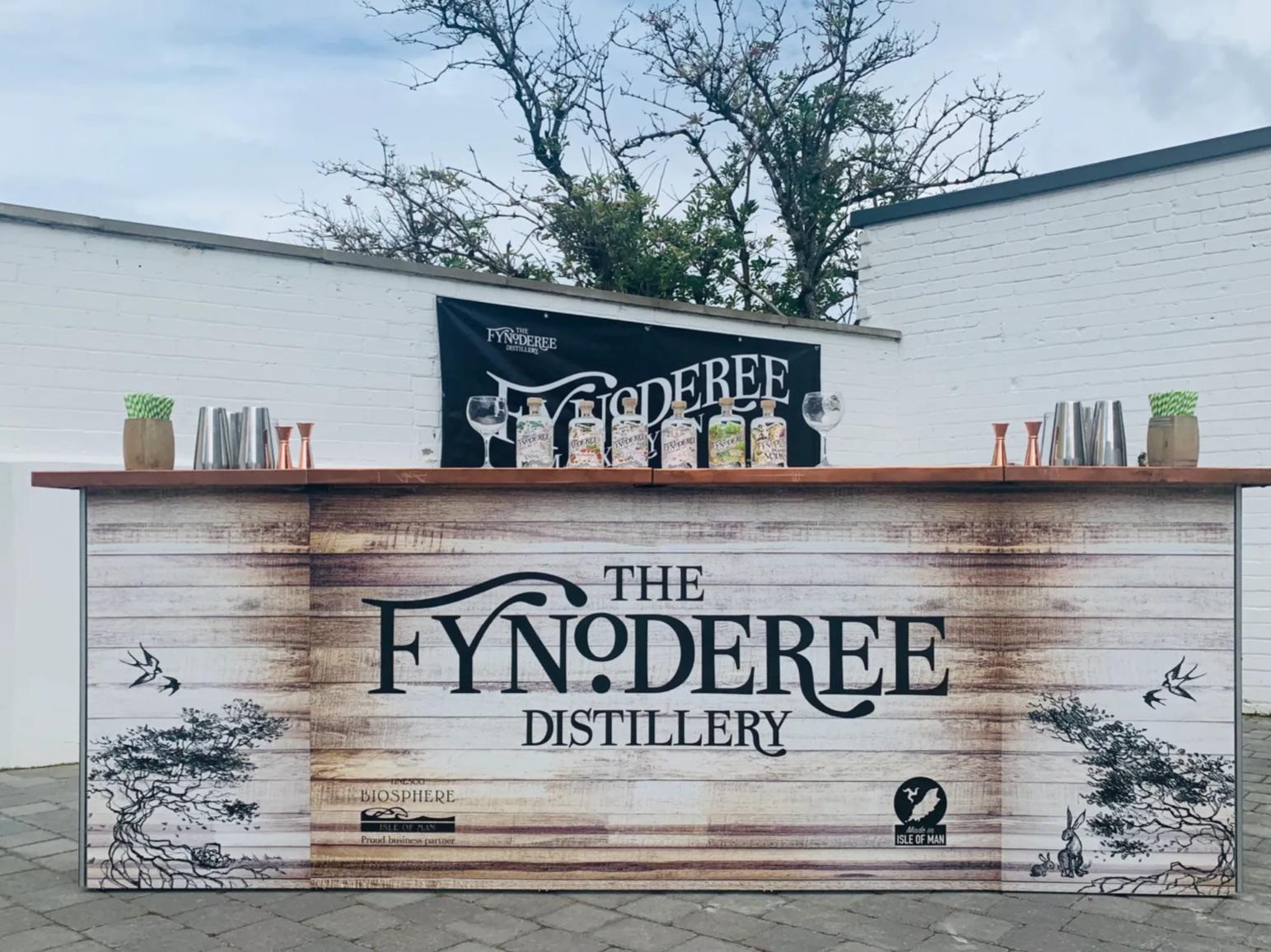 The Fynoderee Pop Up Bar, its printed front carrying the distillery's branding, the counter set with gin bottles, glassware and cocktail kit